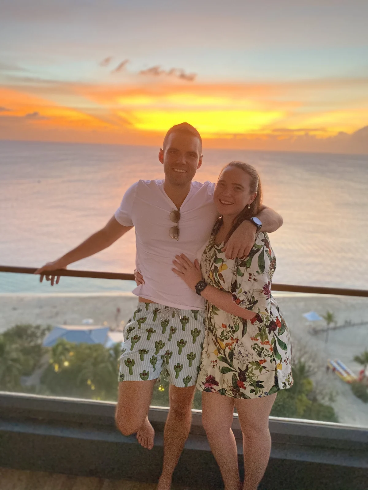 Gem and Bill arm in arm at sunset, the sea glowing gold behind them