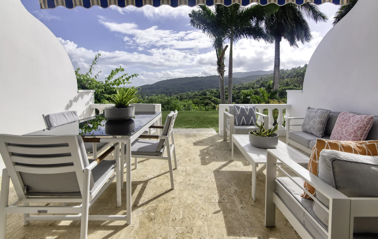 A villa terrace with lounge seating and hill views